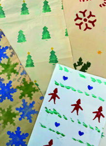 sheets of homemade wrapping paper laid out side by side.